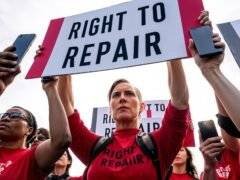 Protesters holding "Right to Repair" signs in unison.